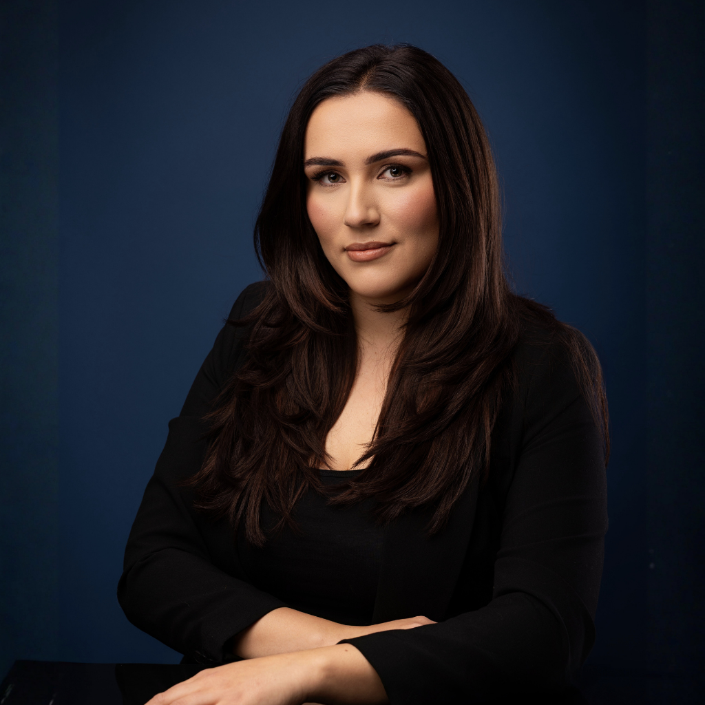 Portret Radca Prawny Koszalin Justyna Rodowicz na ciemnym tle, w eleganckim stroju biznesowym.